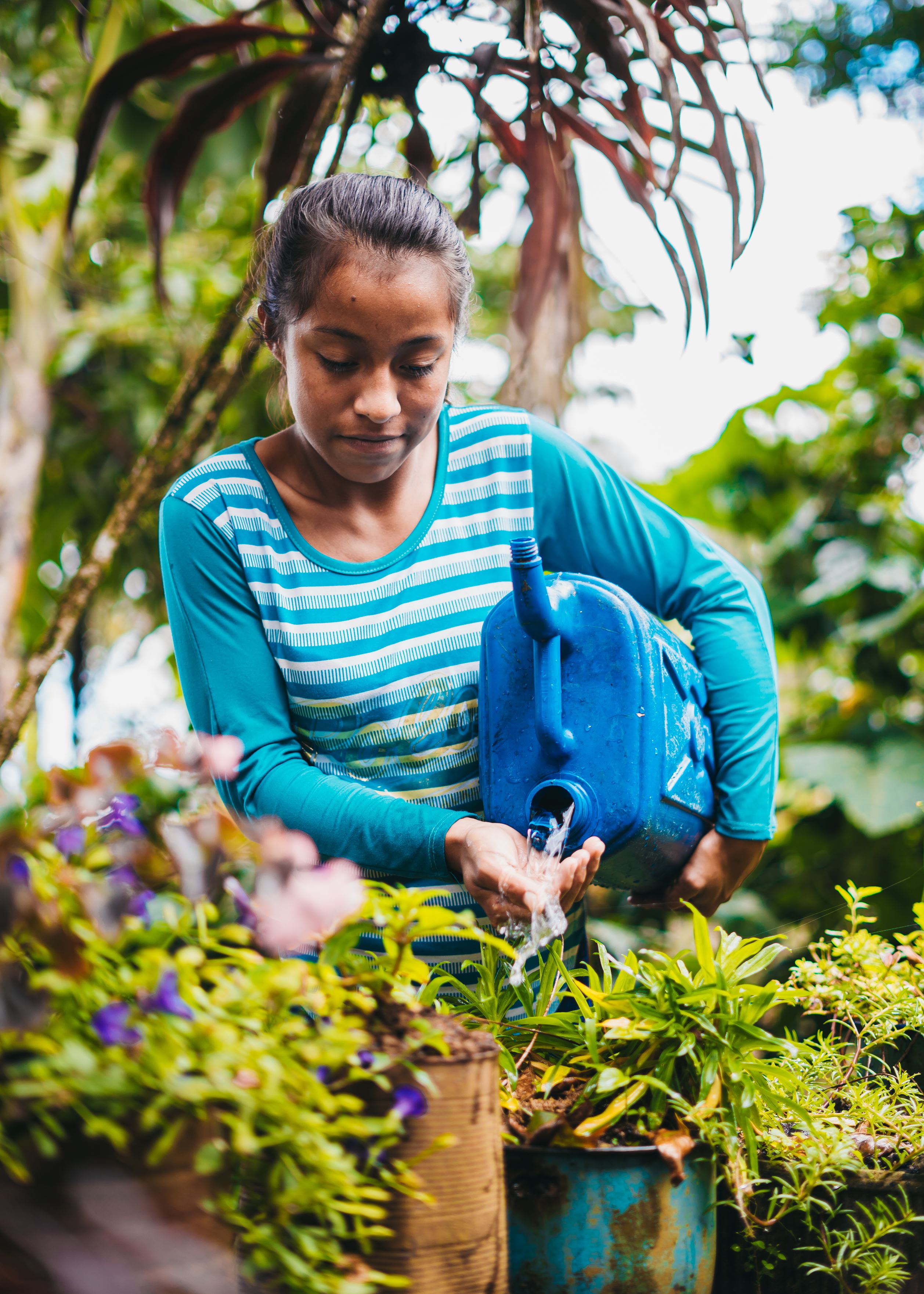 Niña apadrinada de Honduras regando sus plantas