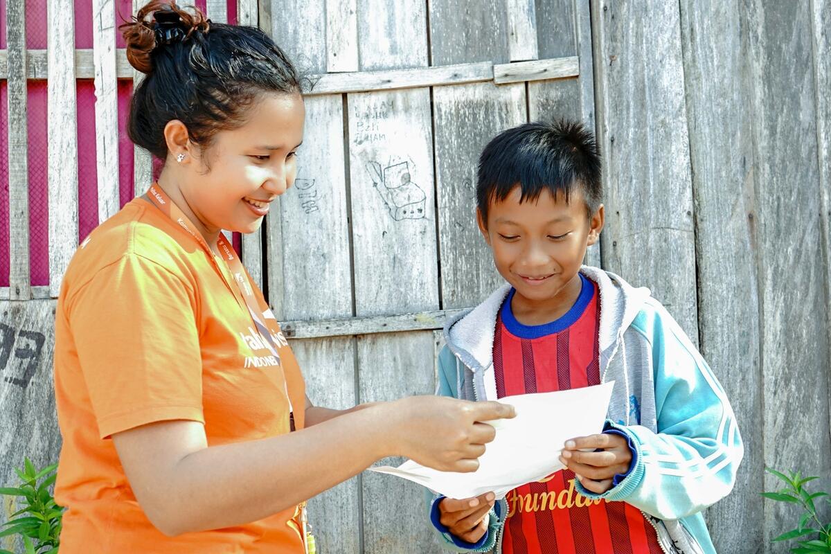 Jackly, de Indonesia, está feliz de leer una carta de su padrino. Recibe la carta de un miembro personal