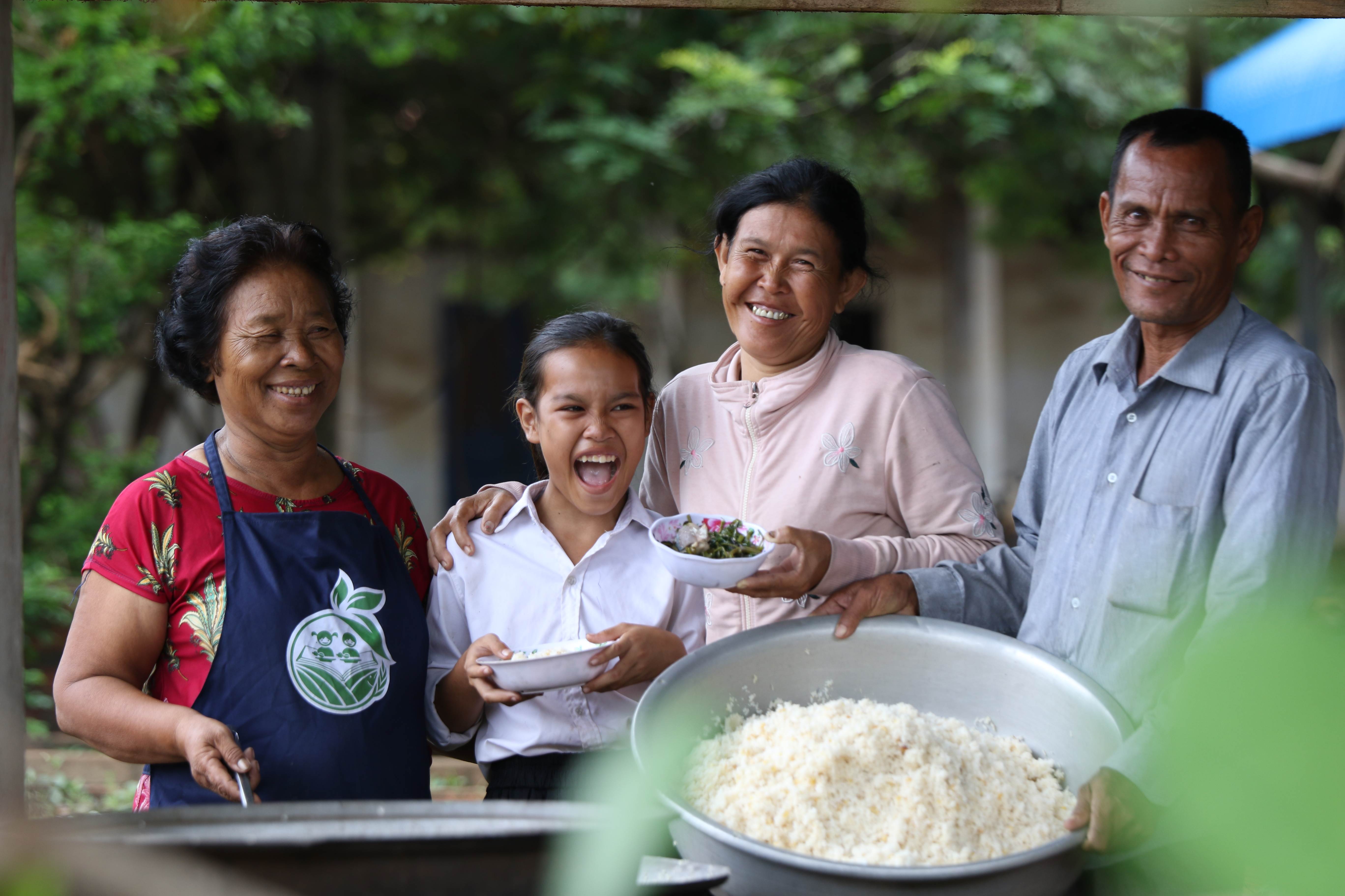 Niña y su familia posan con comida ante la cámara