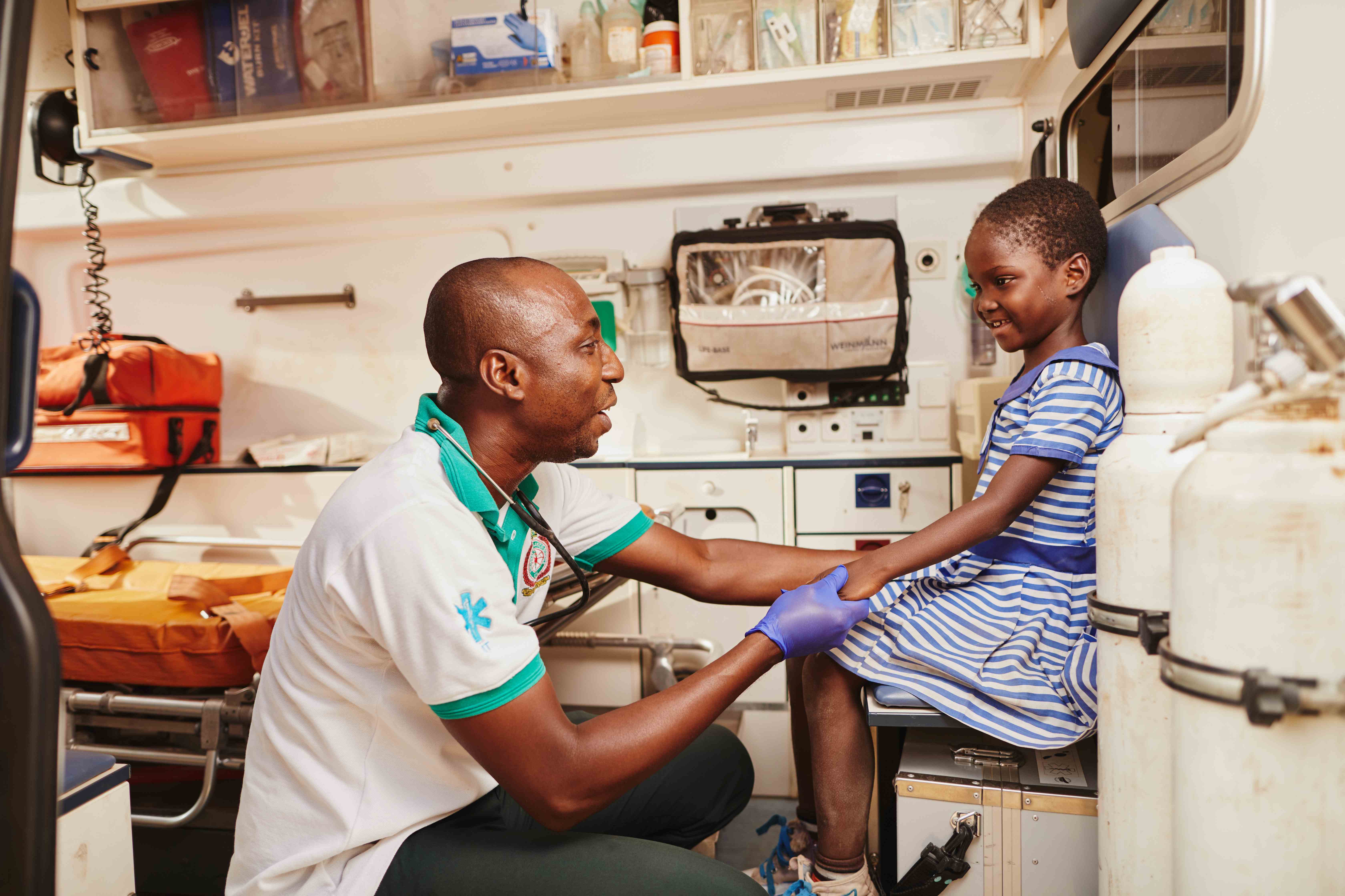 Niña en Ghana siendo examinada por un médico en una consulta.