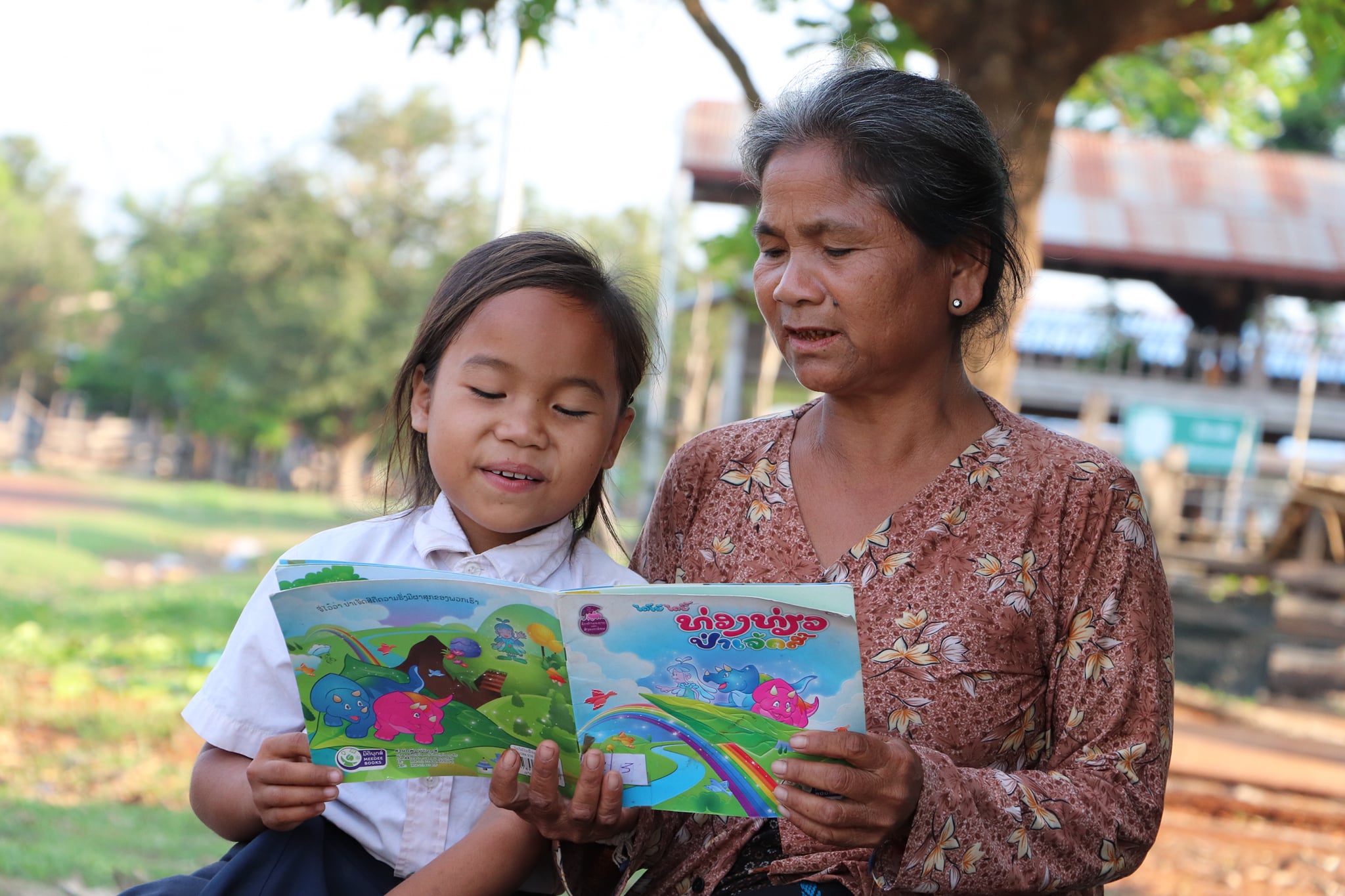 Niña de Laos leyendo un cuento infantil con su abuela