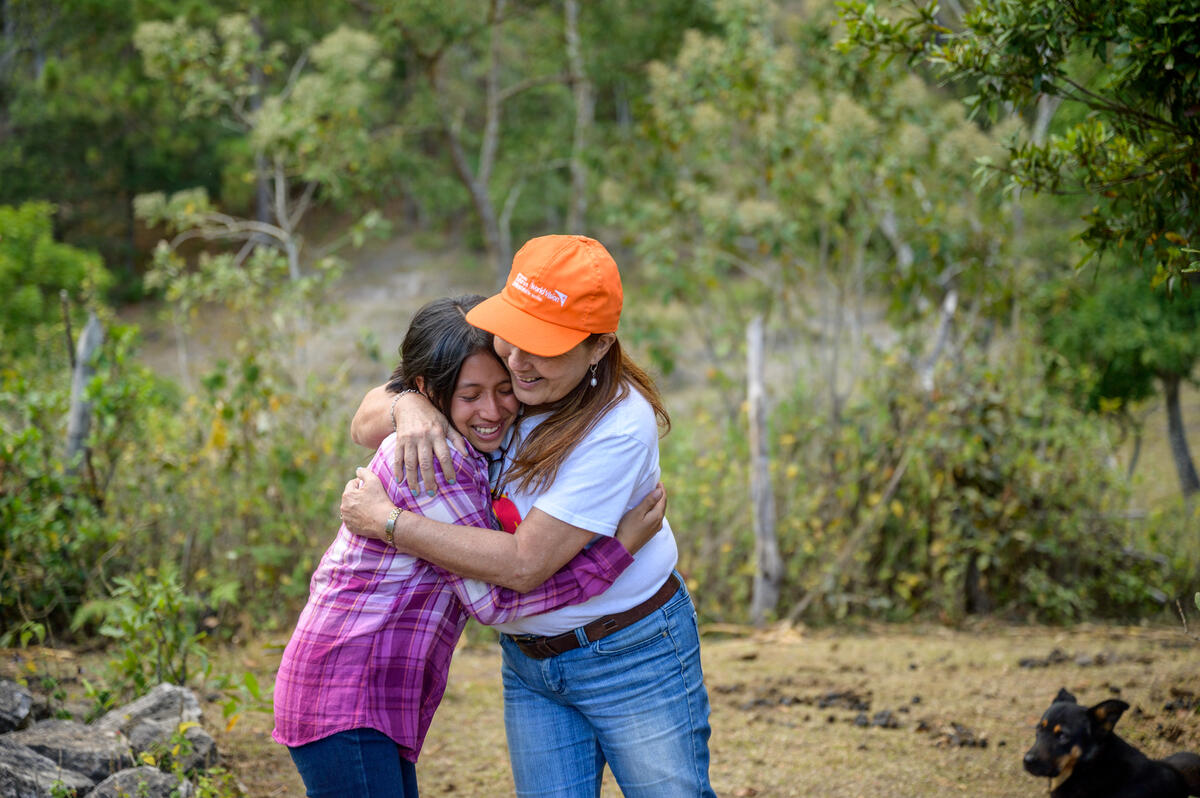 Un miembro del personal abraza a niña en Honduras
