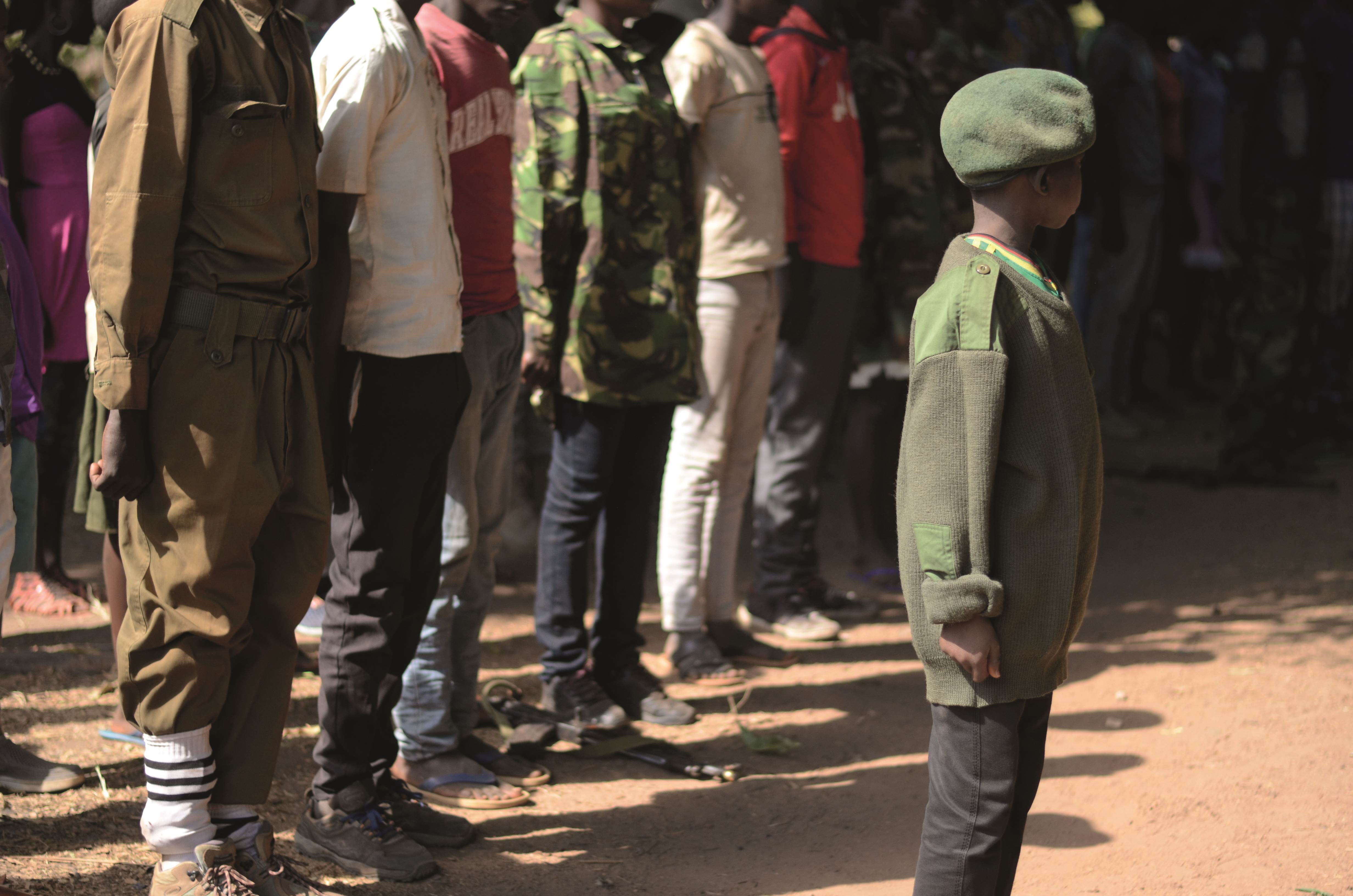 Personas hacen fila detrás de un niño vestido con camuflaje del ejército y una boina en Sudán del Sur