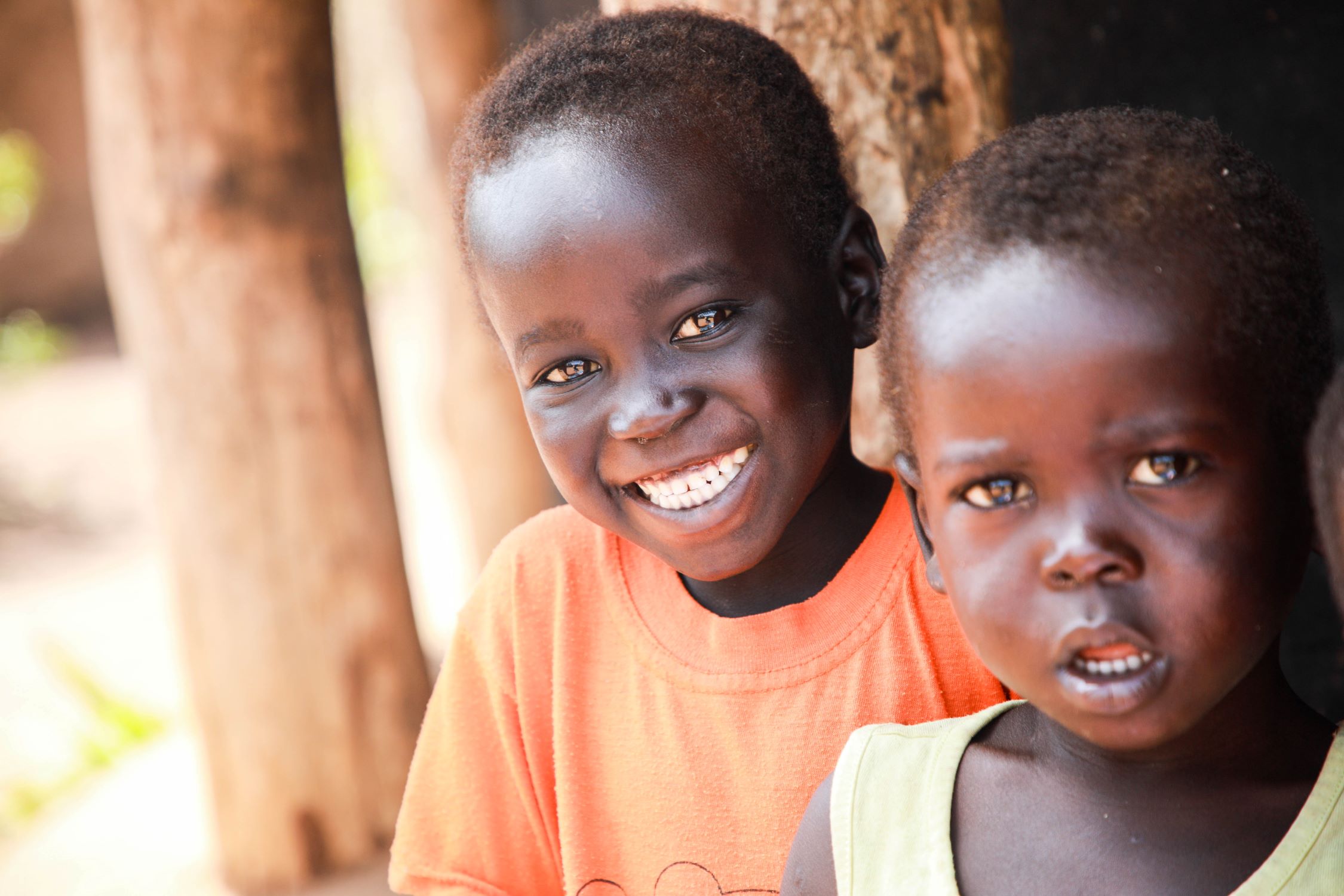 Dos niños mirando a cámara y sonriendo. 