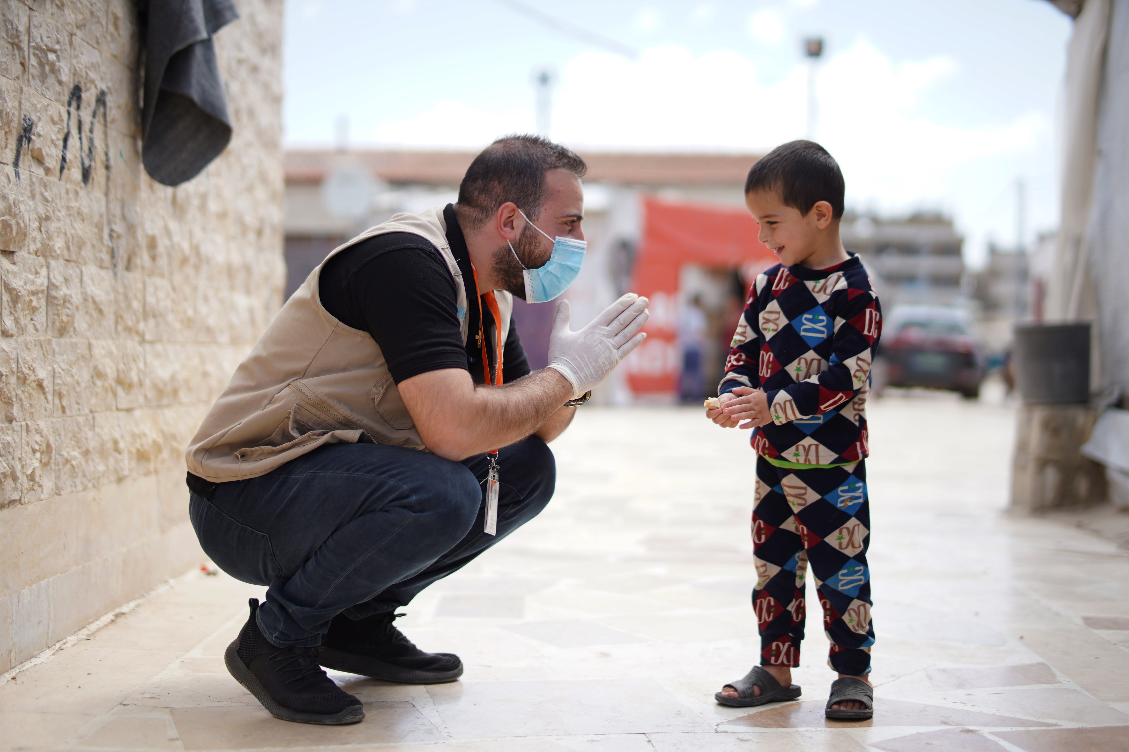 Un miembro del equipo de World Vision en el Líbano hace un amigo mientras distribuía puerta a puerta lejía y productos desinfectantes a los refugiados sirios