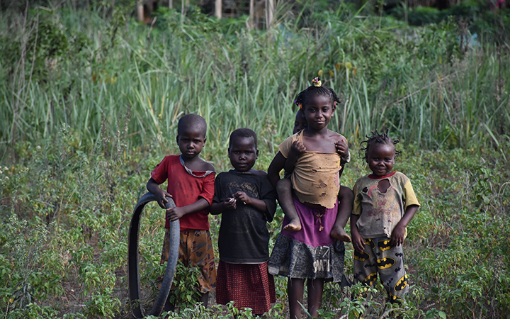 cuatro niños refugiados en Uganda entre matorrales