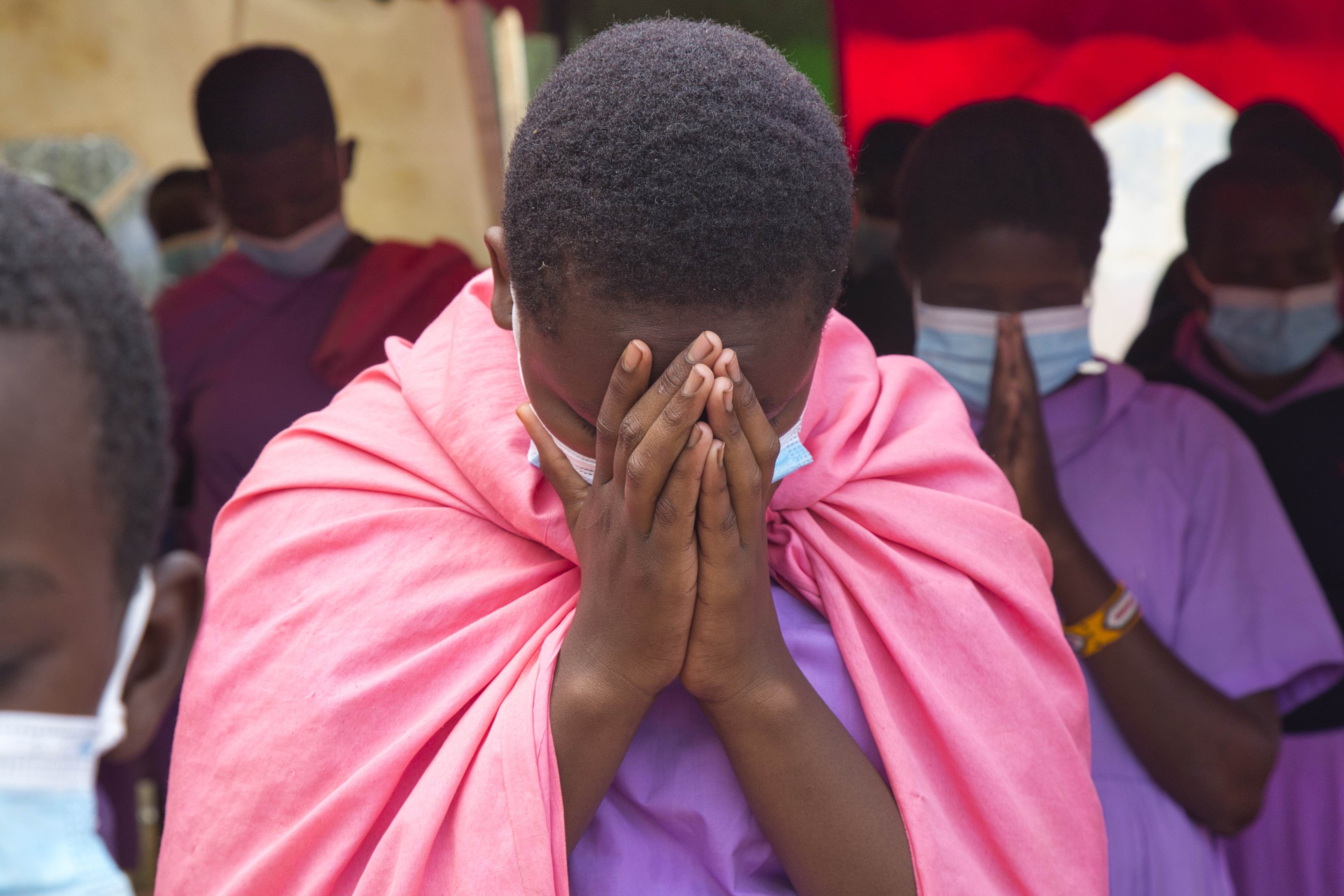 Niña de Kenia en una sesión de oración, con las manos juntas y rezando.