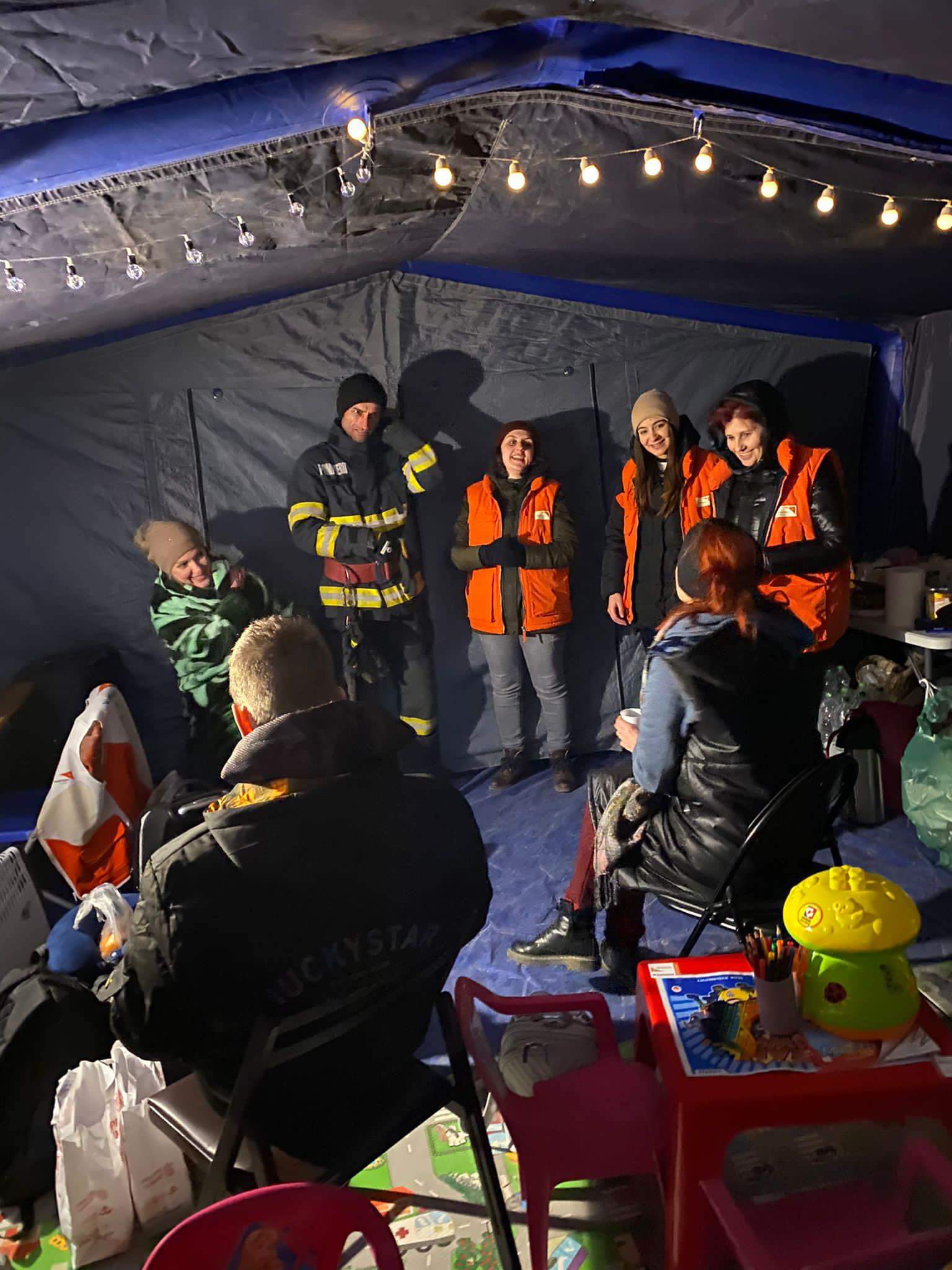 La voluntaria Andreea habla con un grupo de personas en el campo de refugiados de Husi (Rumanía).