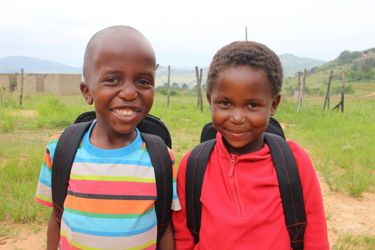 Niños con mochilas escolares a la espalda