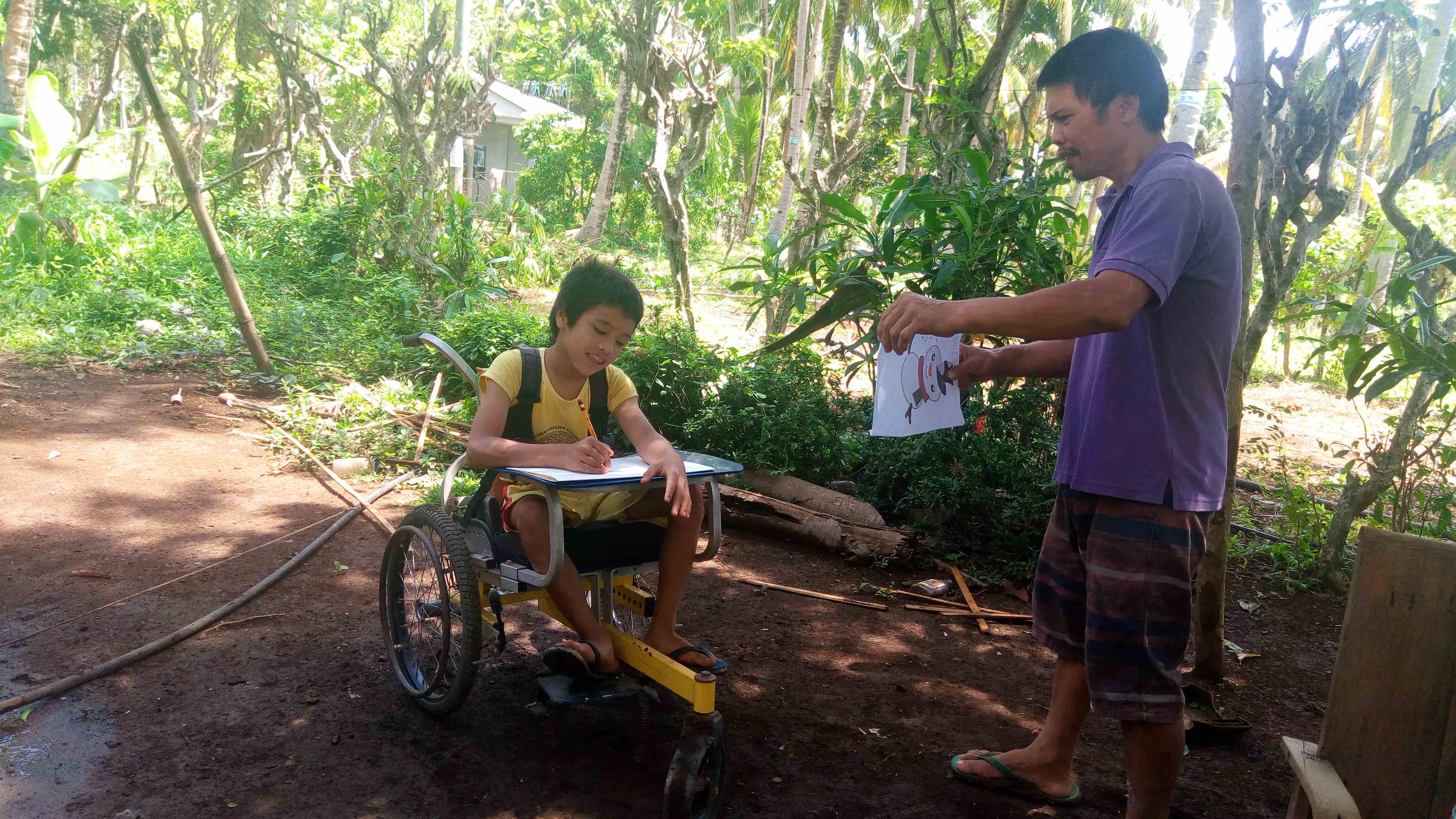 Un filipino enseña a un niño en silla de ruedas a salir al aire libre