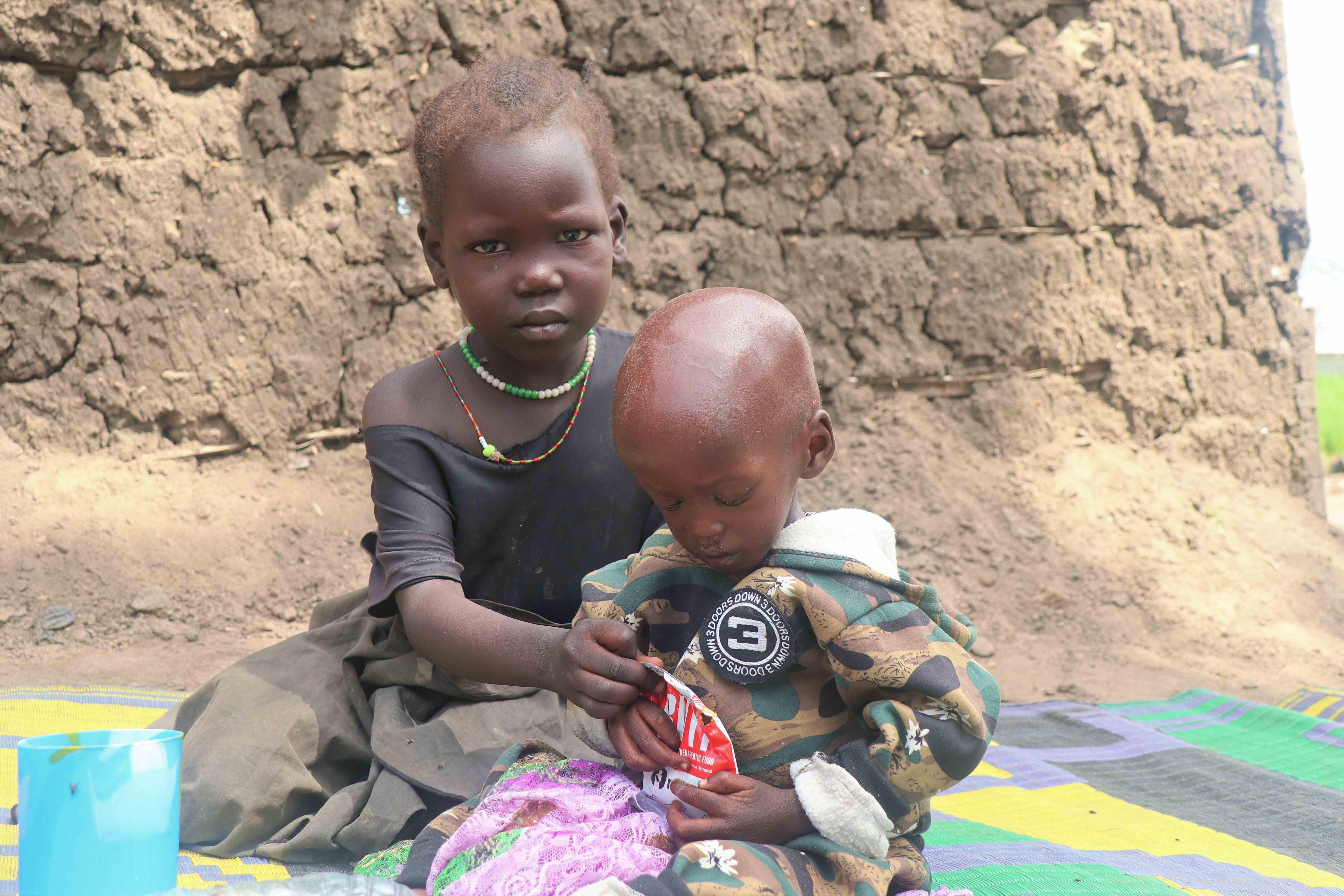 Ocan, de Sudán del Sur, comparte las provisiones de RUTF (alimentos terapéuticos listos para usar) con sus primos y hermanos, mientras la crisis del hambre sigue acechando. 