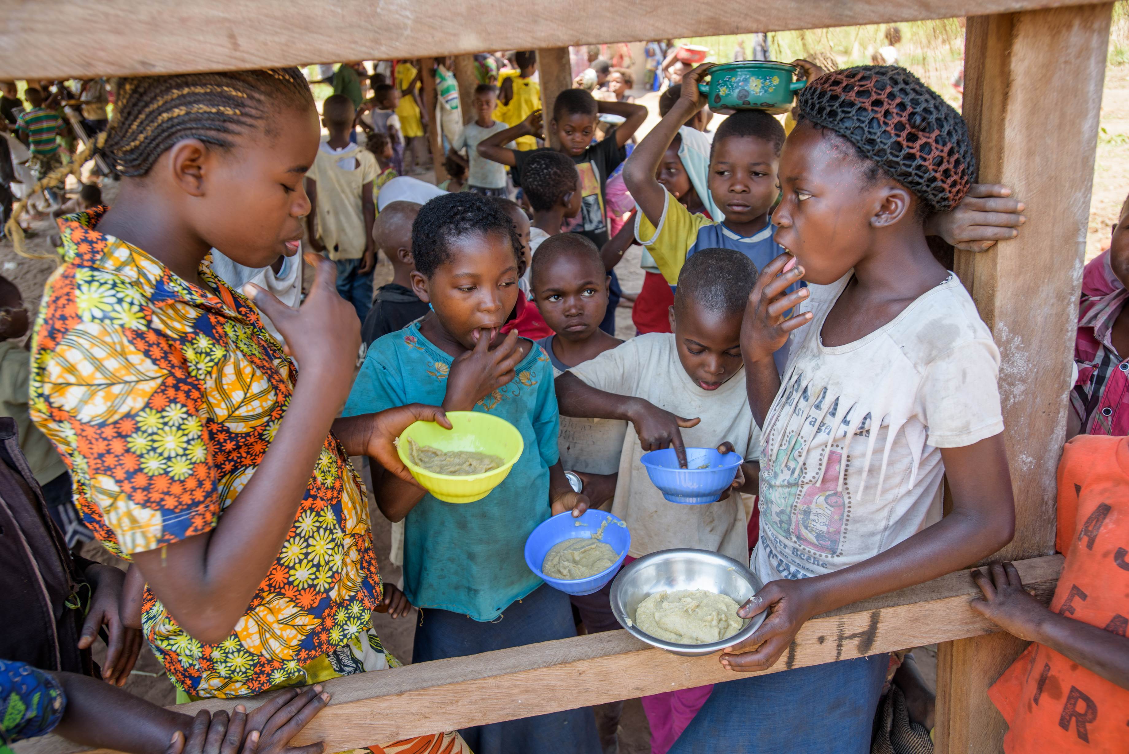 Marie Ngalula, de 14 años, de la República Democrática del Congo, come gachas de avena nutritivas en un espacio acogedor para los niños cerca de su casa