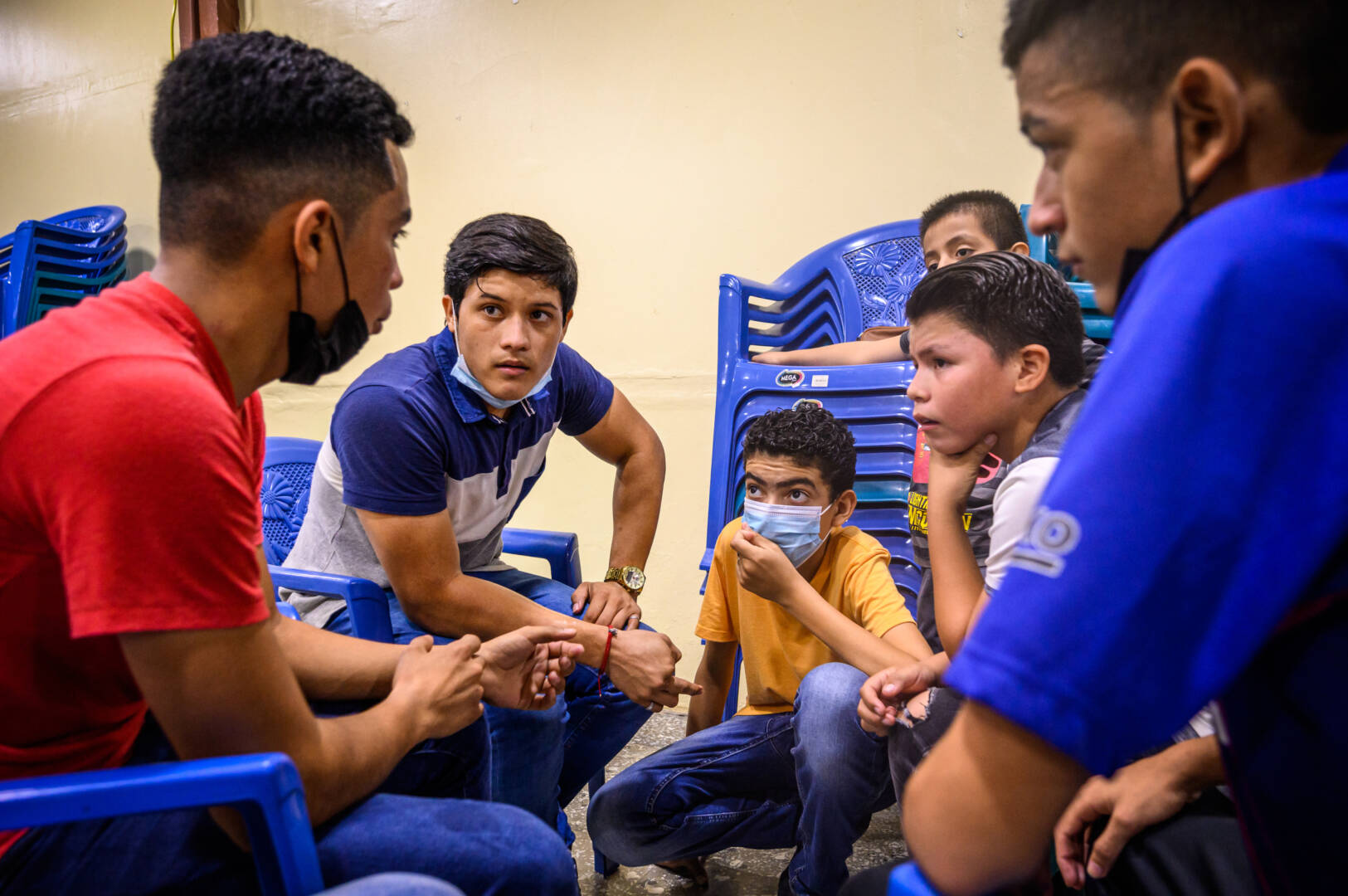 Jordy (con camisa azul y gris) dirige un grupo de jóvenes varones en la iglesia.
