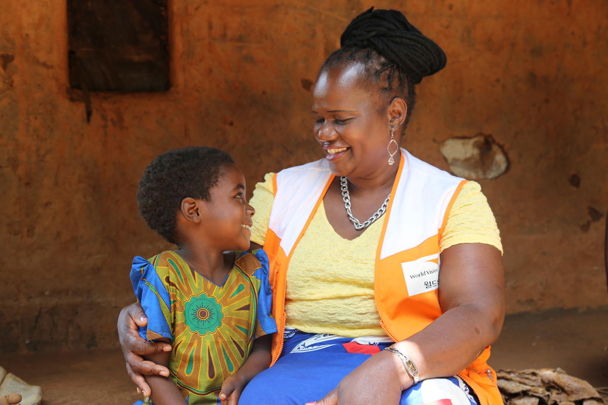 Chimwemwe Mizaya, un miembro del personal de World Vision, visita a Tonthozo, un niño apadrinado en el distrito de Ntchisi en Malawi