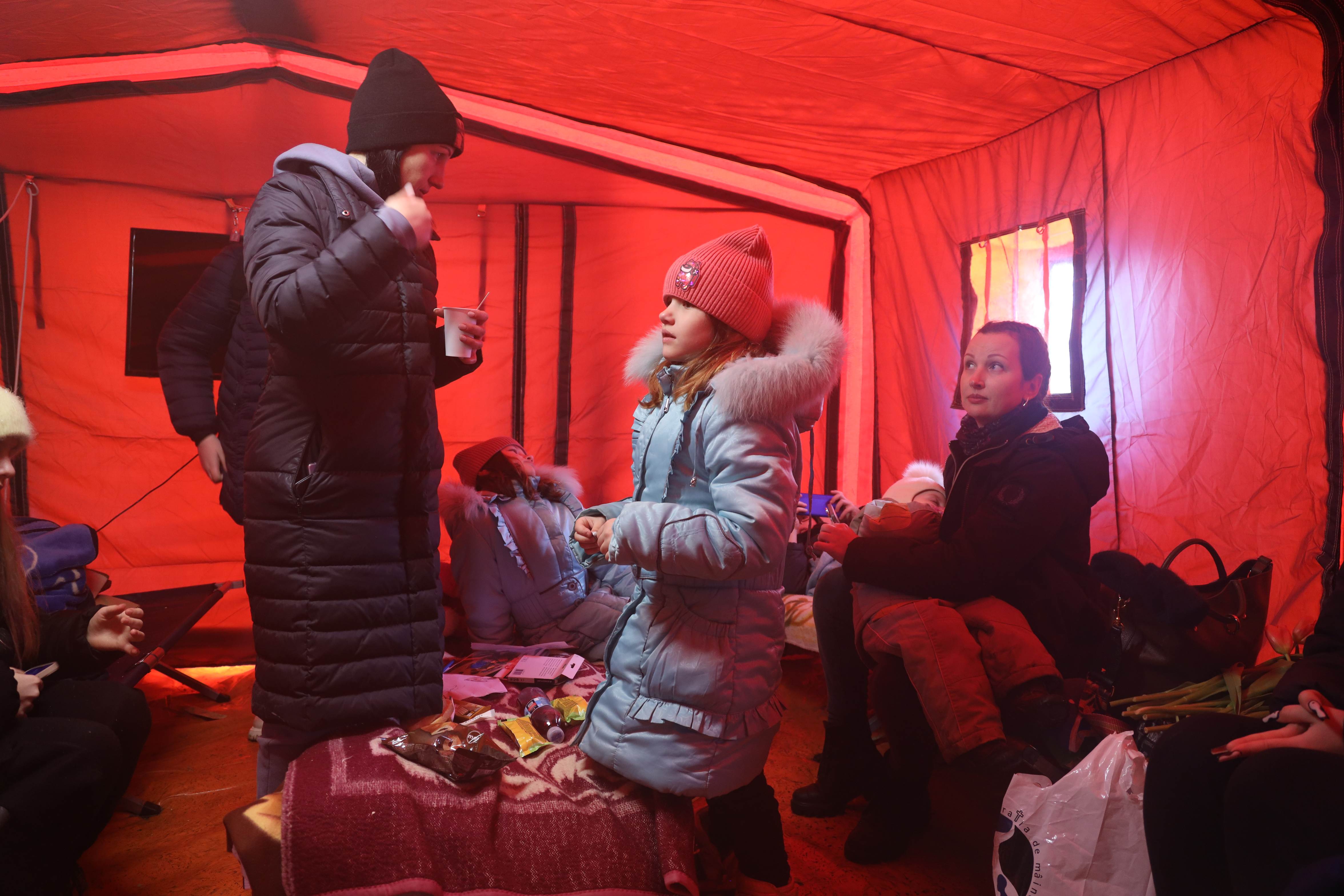 Julia hablando con sus gemelos en una tienda de campaña para refugiados en Rumanía