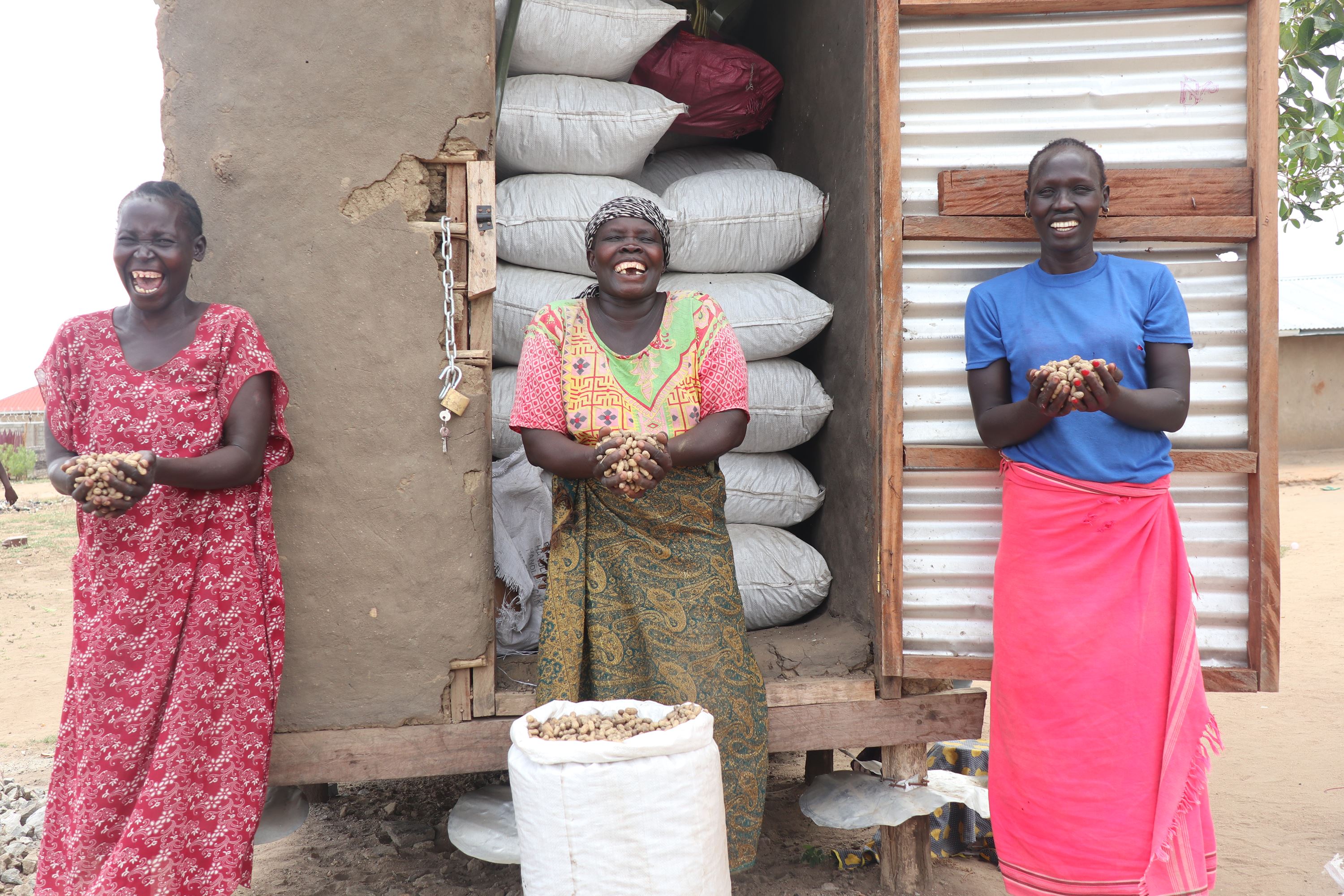 Tres mujeres ríen con las manos llenas de semillas