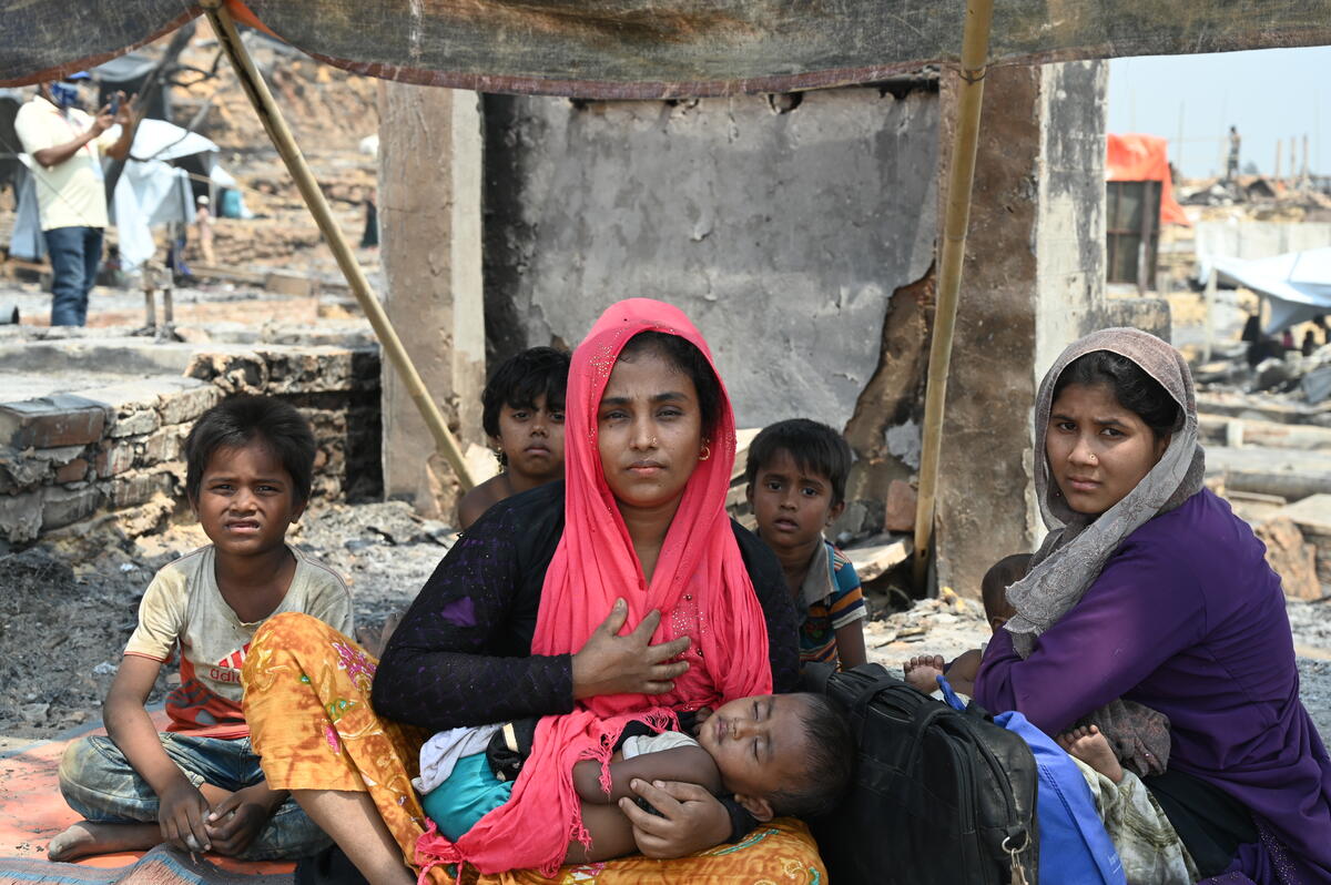 Una mujer en un campo de refugiados en Bangladesh, junto a sus cinco hijos lograron sobrevivir después de un incendio