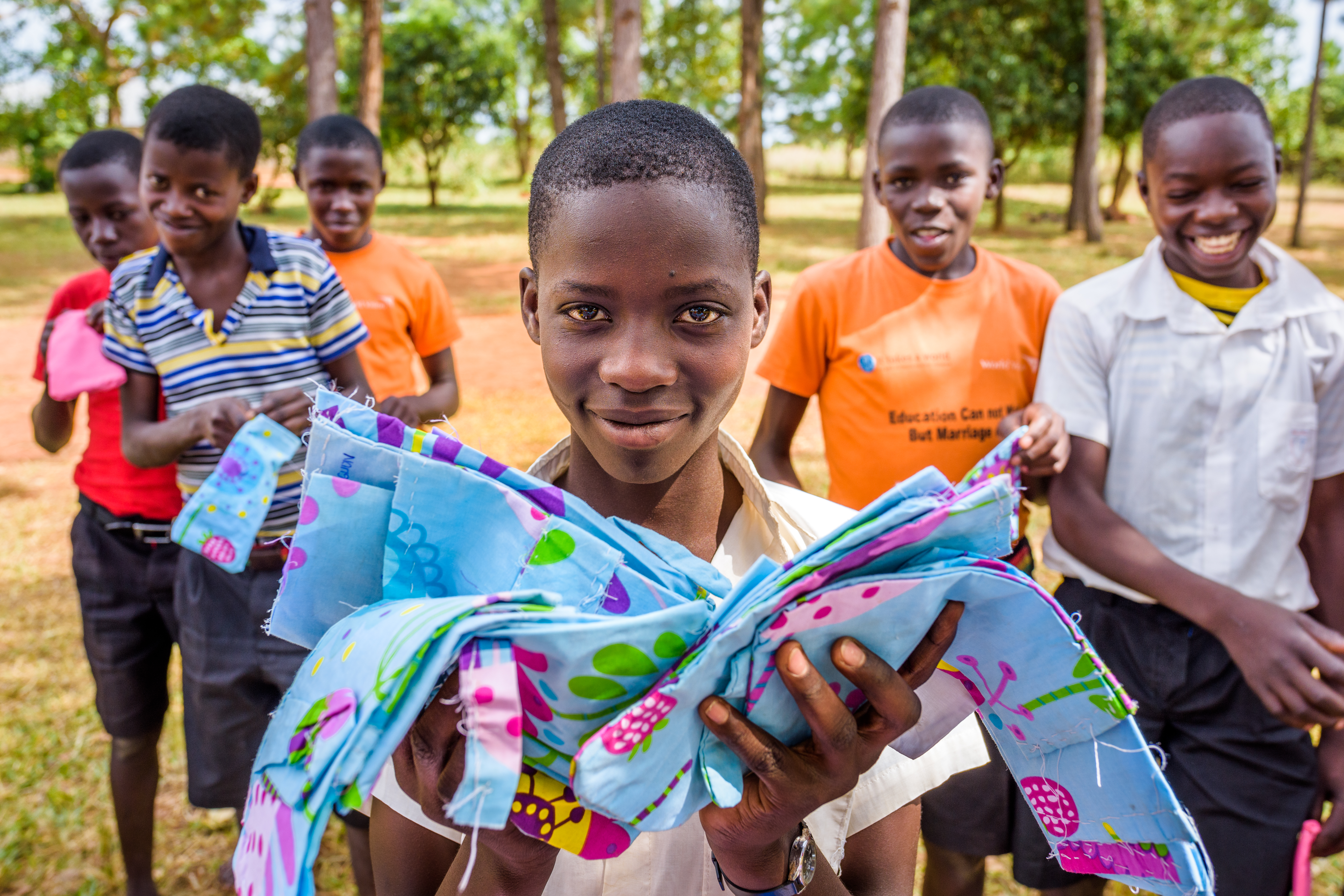 Un grupo de escolares ugandeses muestran las compresas reutilizables que crearon en clase.