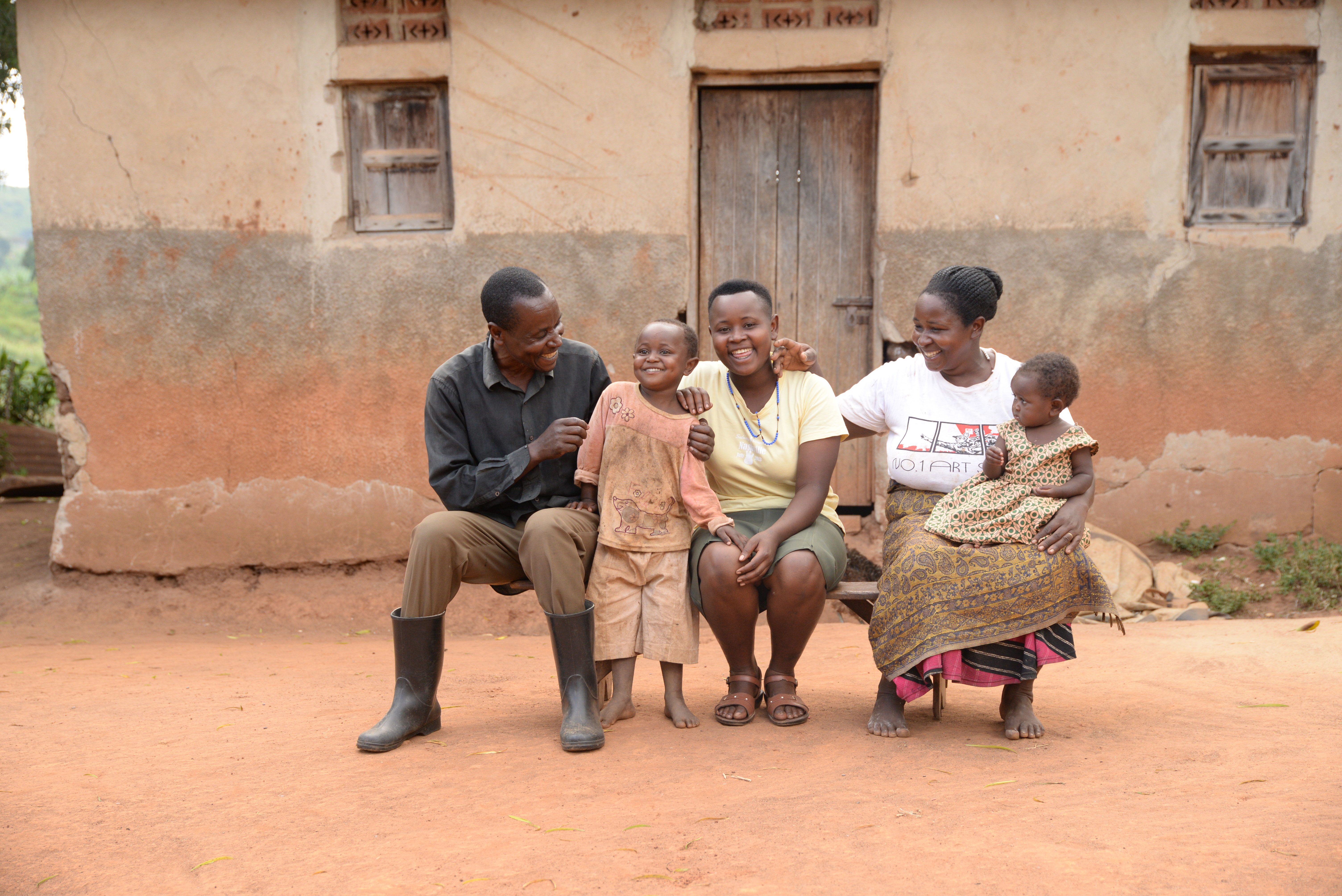 Juliet y su familia de Uganda están sentados frente a su casa