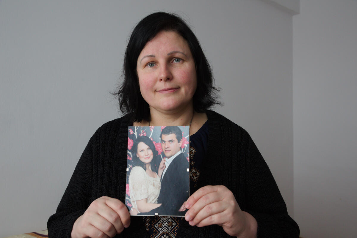 Julia, de 45 años, sostiene una foto en la mano, una imagen de ella con su marido Leonid