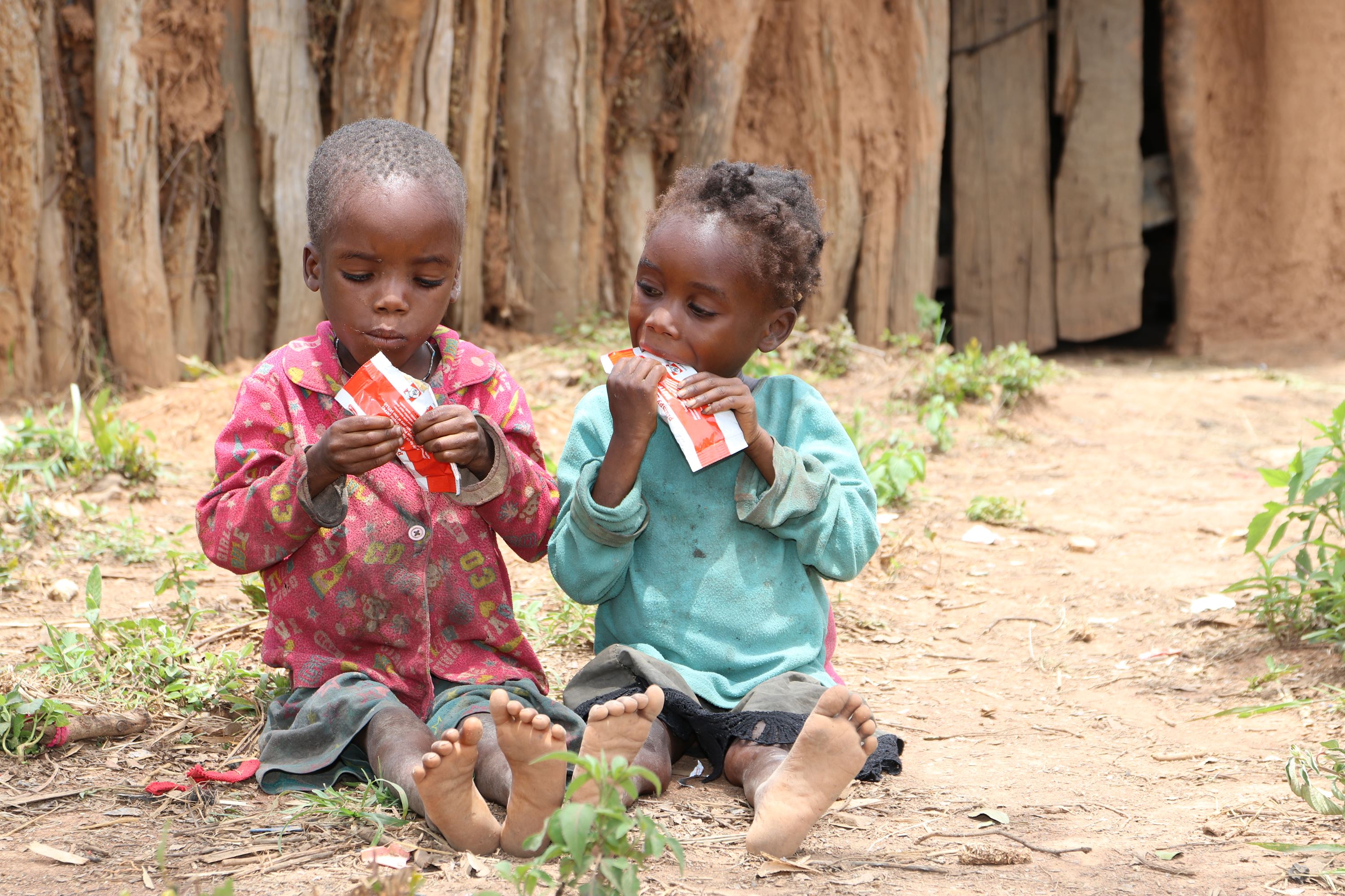 Dos niños comiendo alimento terapútico
