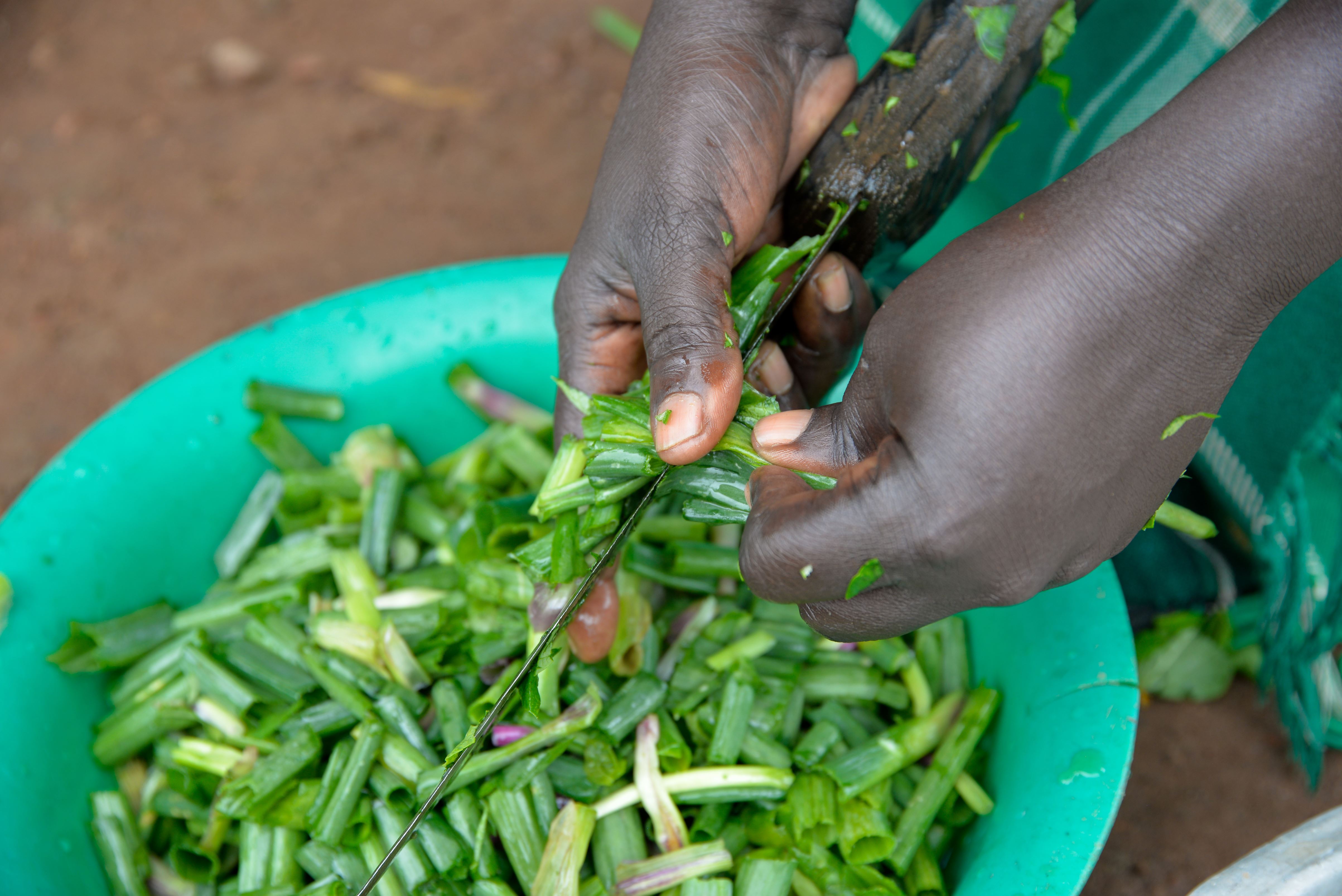María, de Uganda, está cortando cebollas.