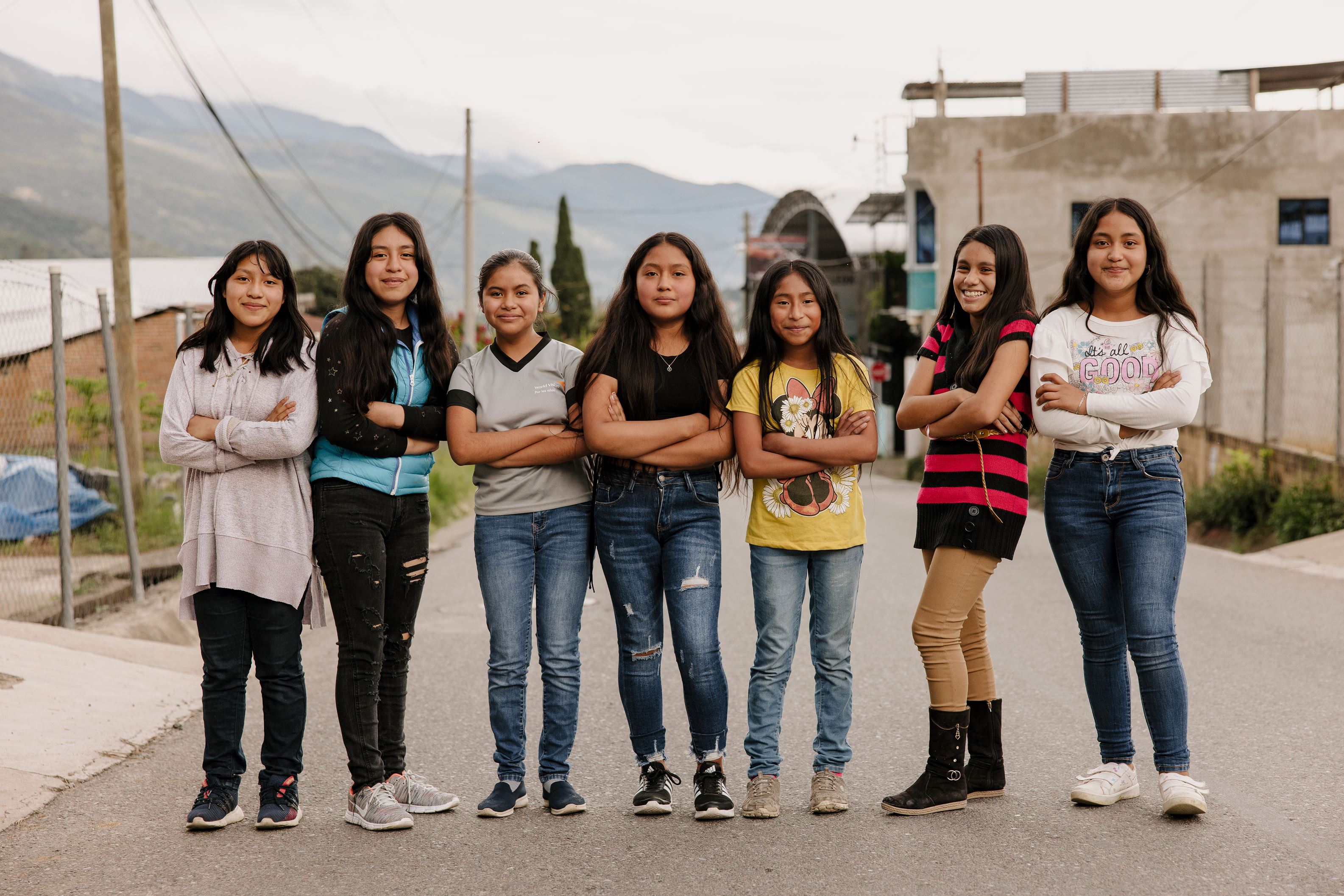 Un grupo de niñas guatemaltecas de brazos cruzados en una carretera