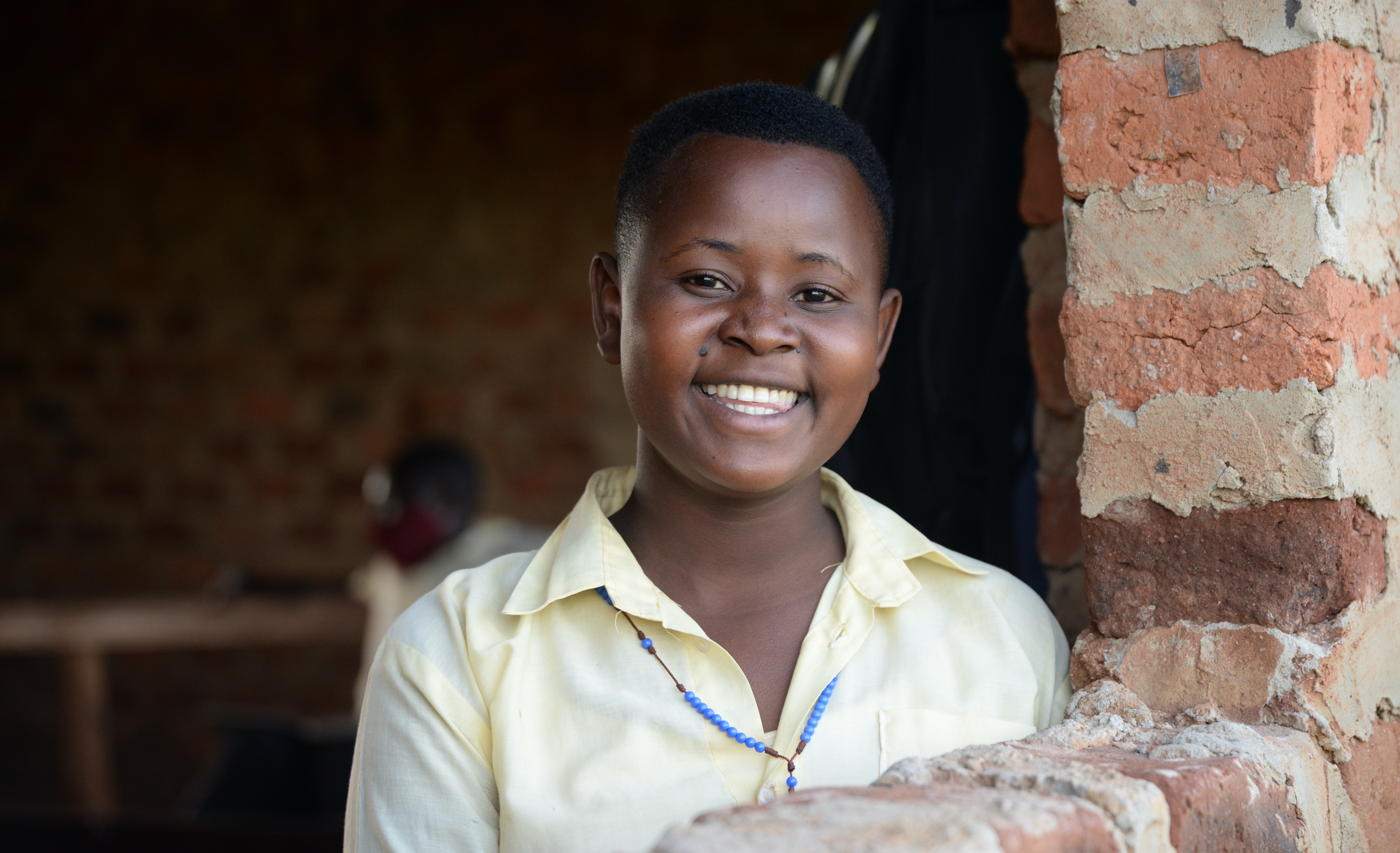 Juliet de pie junto a la ventana de clase en Uganda