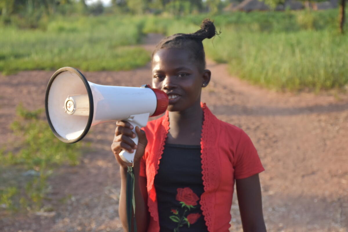 Priscillia, de 12 años, usa un megáfono para compartir mensajes de protección con su comunidad