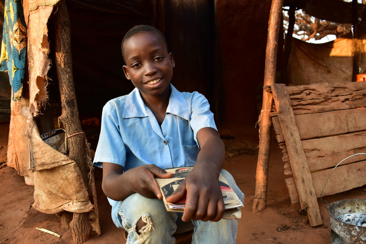 Swangirai, de 12 años, de Zambia, está sano y está sentado con un libro en la mano