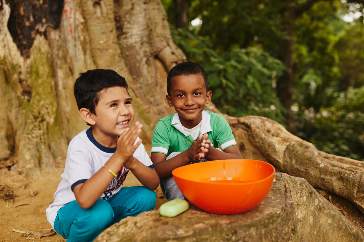 Jeferson, 5, and Marlon, 6, from Colombia, practice good hygiene together, using a clean water source and soap.