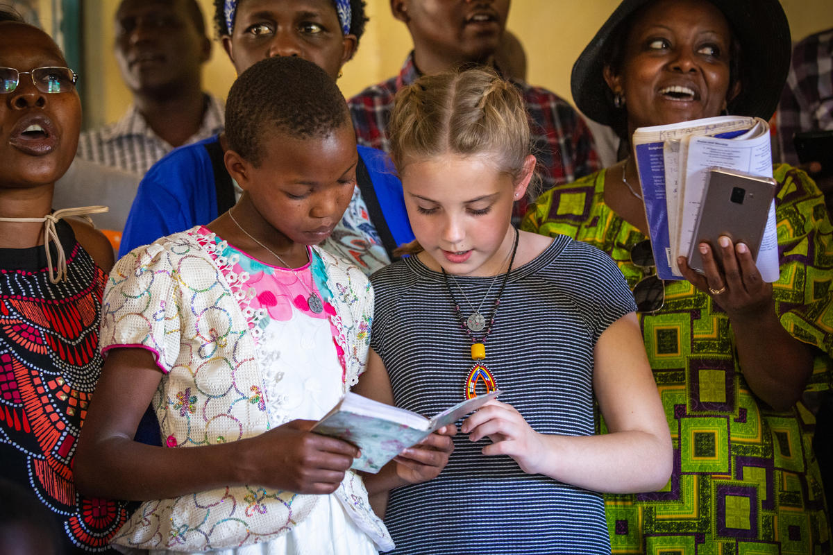 Maurine, a la izquierda, y Addyson cantan una canción de alabanza junto con el personal de World Vision en Kenia.