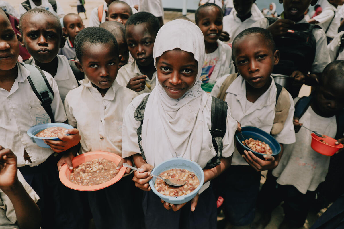On 16 March 2023 in Myunzi, Tanzania, 9-year-old Rukia (white hijab) holds a plate of food in front of the camera, while her classmates do the same.
Because of a prolonged drought causing intense water and food insecurity, feeding programmes are necessary in the area. Many girls skip school to fetch water and travel long distances to acquire the liquid and sometimes food.
The school is routinely check to determine if they are well equipped with the necessary resources. This has helped in a great academic improvement, placing Kwamzindawa as the best performing school in the district.
World Vision (WV) helped rebuild The Kwamzindawa Primary school by providing basic construction materials and many of the children who attend the school are sponsored by WV.
The daily school feeding programme at the Kwamzindawa is funded by WV Hong Kong.